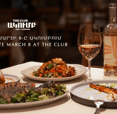 Gourmet dinner plates and a bottle of rose wine at The Club restaurant in Yerevan for March 8th celebration.