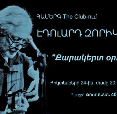 Eduard Zorikyan performing live concert at The Club with acoustic guitar and blue filter.
