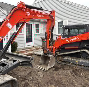 A Kubota mini excavator and SVL 75-3 skid steer perform residential excavation for a new patio.