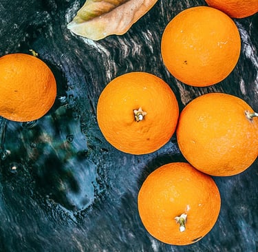 arance intere disposte su un tavolo di pietra verde