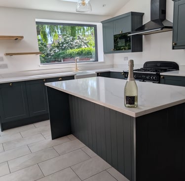 white and darkgreen kitchen with champagne on counter top with wooden shelves