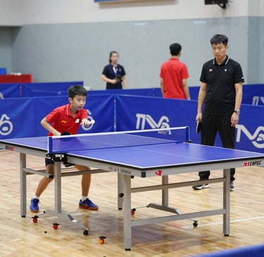 A Sri Lankan table tennis academy session, with coaches demonstrating techniques to attentive students.