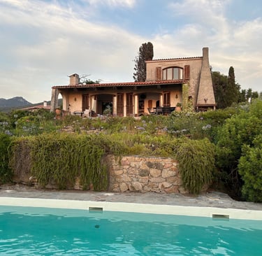 Luxury Mediterranean villa with a private swimming pool and lush garden landscape in Sardinia.