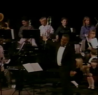 The kindergartners wait patiently as the beginning band (fifth grade) finishes their performance.