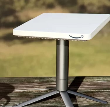 Amazon Project Kuiper satellite internet terminal mounted on a wooden surface with a grassy background.