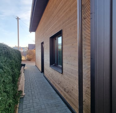a house with a wooden siding and a brick wall