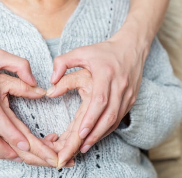 Deux personnes se tiennent les mains et forment un coeur.