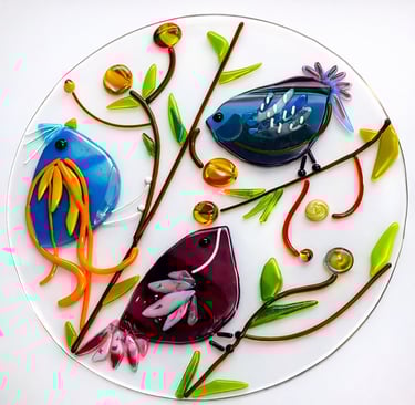 Colorful fused glass birds on branches on circular glass base