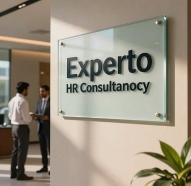 Professional corporate office lobby with a sleek glass signage plaque reading Experto HR Consultancy in an upscale commercial park in Ghaziabad, warm natural lighting, modern South Asian / Indian business professionals.
