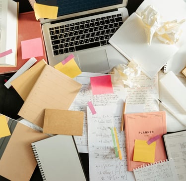 A desk with a notebook open, several pages filled with notes, suggesting deep consideration rather than rushed activity.