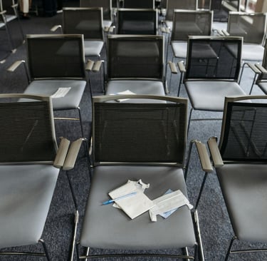 Meeting room with empty chairs symbolizing silence and disengagement caused by psychological safety issues.