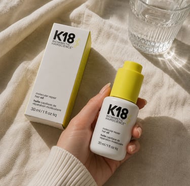 Hand holding K18 hair oil for smooth and shiny hair care routine.