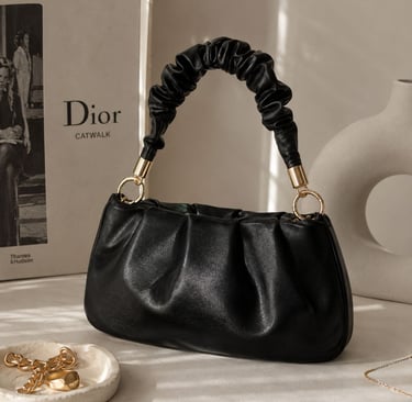 Ruched black bag with luxury background.