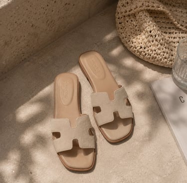 Beige neutral slide sandals with suede finish.