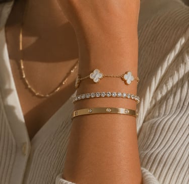 Luxury gold bracelet stack on wrist.