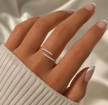 Gold crystal open ring with sparkling stones worn on a hand with a soft knit sleeve.
