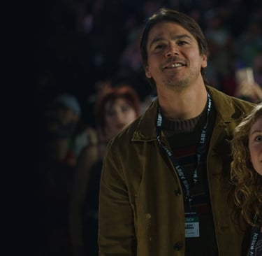 A man holds his daughter at a concert