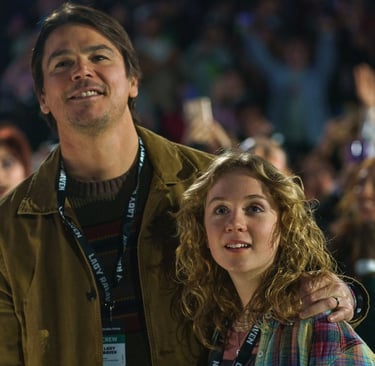 Josh Hartnett and Ariel Donoghue as a father and daughter in a crowd at the Lady Raven concert in the movie Trap.
