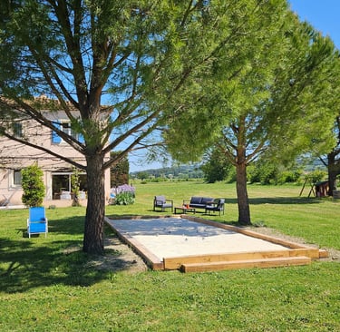 Vue sur la maison d'hôtes la Ramade et son terrain de pétanque.