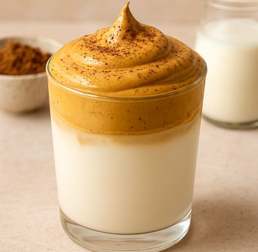 Glass of homemade Dalgona coffee with whipped coffee foam over milk, an easy budget-friendly coffee 