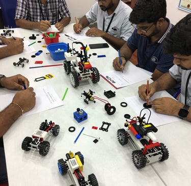 Group of kids proudly displaying their finished robotics projects, smiling against the backdrop of a modern classroom.