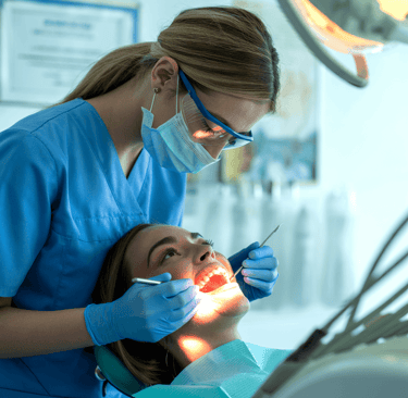 Professional dentist performing a dental checkup and teeth cleaning on a patient in a clinic.