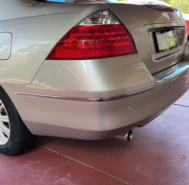 Rear view of a silver Honda Accord showing freshly refinished taillight, bumper, and exhaust pipe.