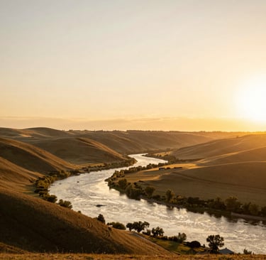Golden sunset over a winding river valley with rolling hills and lush riverside trees.