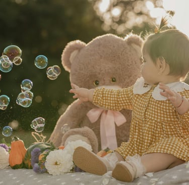 a baby doll sitting on a blanket with bubbles