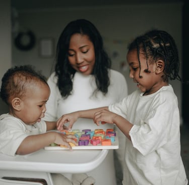 A mother and two young children play with a colorful wooden alphabet puzzle at home.