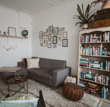 a living room with a couch and a chair and a mini library