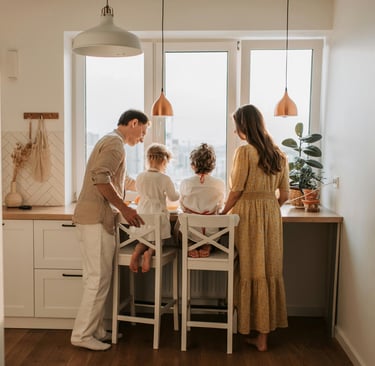 a family of four people standing around a table