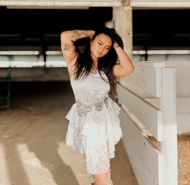 a woman in a white dress and cowboy boots