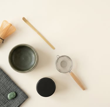 matcha tools arranged chawan chasen chashaku furui natsume chakin on a clear surface