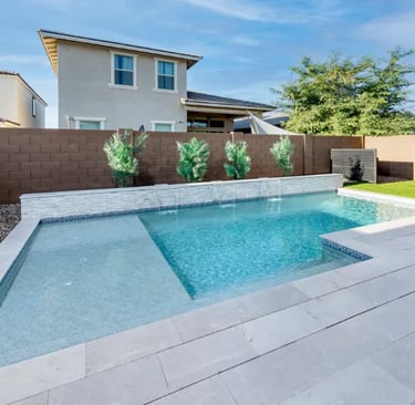 Modern geometric pool with pale blue water and light grey tiles plus a shallow sun shelf.