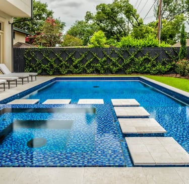 Fully tiled pool with stepping pads, deep blue water and small blue mosaic tile interior.