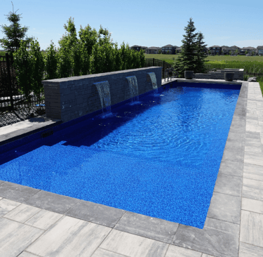 Sleek Rectangle pool with sheer descent water features, vivid blue water and dark mosaic tiling