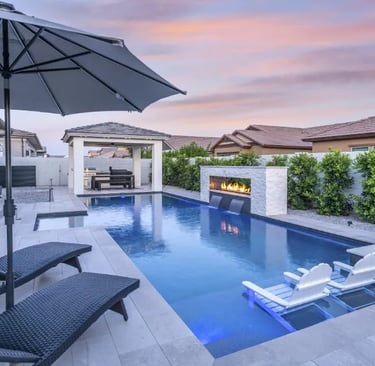 Modern Geometric rectangular pool with dark blue water and light stone tiles beside a fire feature