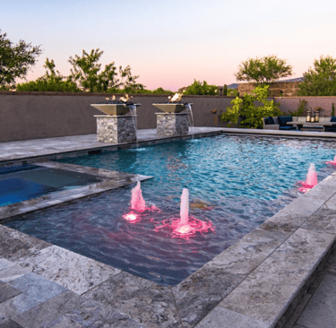 Luxury geometric pool with spa, soft blue water, light stone tiles and illuminated water jets