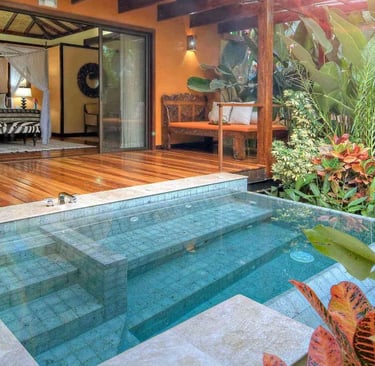 Compact rectangular pool with soft aqua water and green-grey stone tiles in a tropical courtyard des