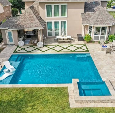 Large geometric pool with vibrant blue water and cream stone tiles with integrated spa.