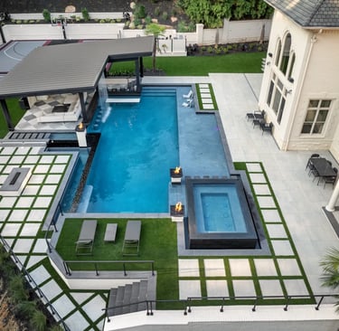Modern geometric pool with deep blue water and light grey tile surrounds.