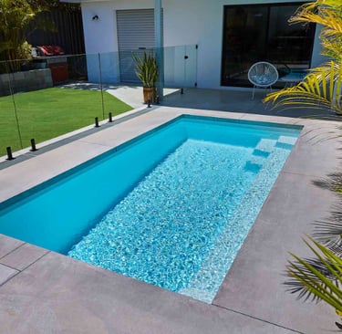 Minimalist courtyard pool with pale aqua water and light tiled interior, clean modern rectangular de
