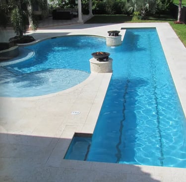 Geometric pool with integrated spa, light aqua water, cream stone coping and blue mosaic tiles