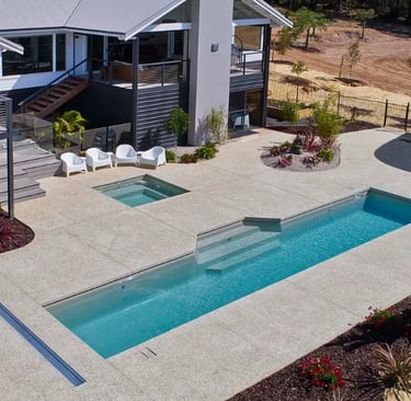 Modern lap pool with clean rectangular design, soft aqua water and light concrete-style tiling.