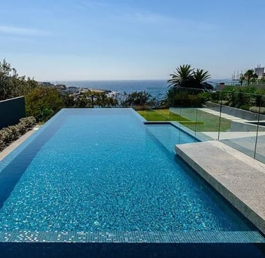 Geometric Infinity-edge pool with bright turquoise water and mosaic blue tiles