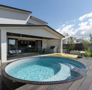 Round plunge pool with pale aqua water and dark charcoal mosaic tiles
