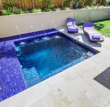 Compact square pool with rich blue water and cobalt mosaic tile interior