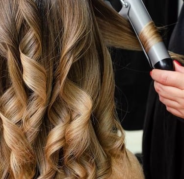 a woman is blow drying her hair in a salon Abu Dhabi