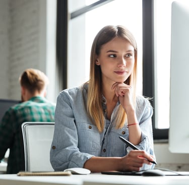 a woman sitting at a desk with a pen and a pen